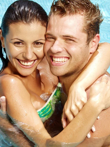 Pareja joven hispana disfrutando en una piscina . —  Fotos de Stock