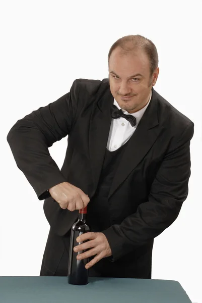 Young sommelier holding a red wine bottle — Stock Photo, Image