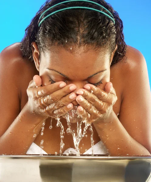 Junge afroamerikanische Frau wäscht ihr Gesicht. — Stockfoto