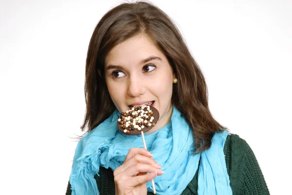 Молодая женщина ест шоколадный леденец — стоковое фото