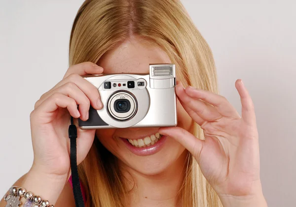 Jovem mulher loira feliz tirando fotos com câmera — Fotografia de Stock