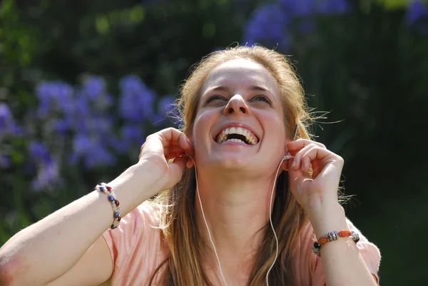 Openlucht jonge vrouw luisteren muziek — Stockfoto