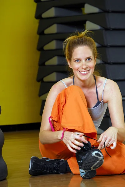Unga blonda kvinnan i ett gym — Stockfoto