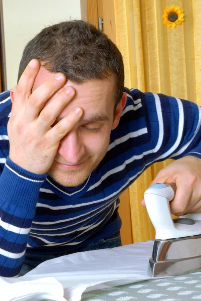 Happy young man ironing on a ironing board — Stock Photo, Image