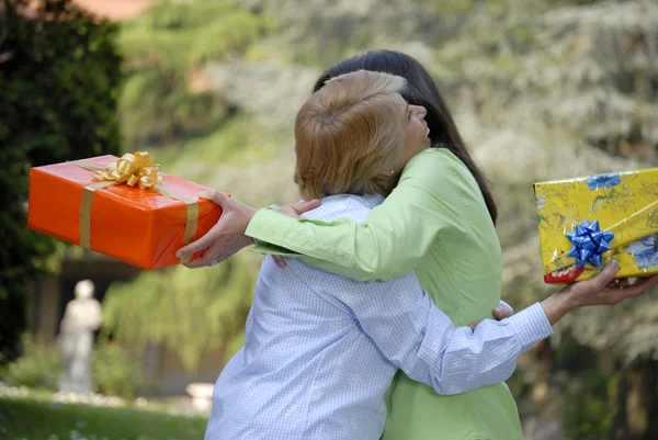 Two womens hugs and holding gifts — Stock Photo, Image