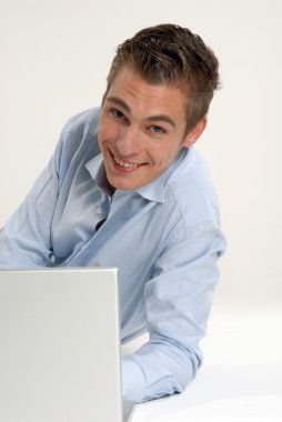 genç ve mutlu bir işadamı ile bir laptop beyaz arka plan üzerinde çalışma.