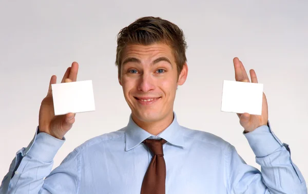 Joven hombre de negocios con dos tarjetas blancas — Foto de Stock