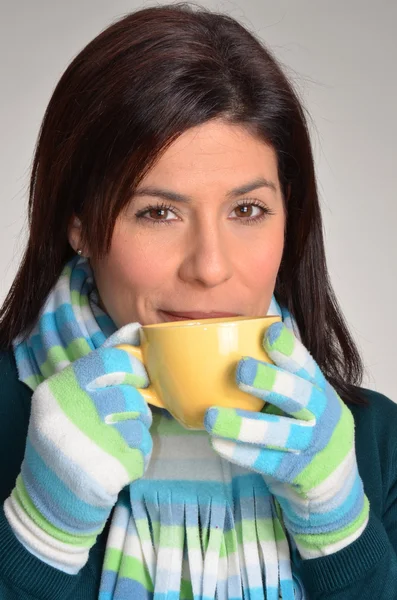 Sarı bir kase tutarak sıcak bir içecek içme kadın kış. — Stok fotoğraf