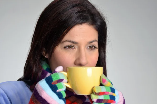 Vintern kvinna dricka varm dryck håller en gul kopp. — Stockfoto