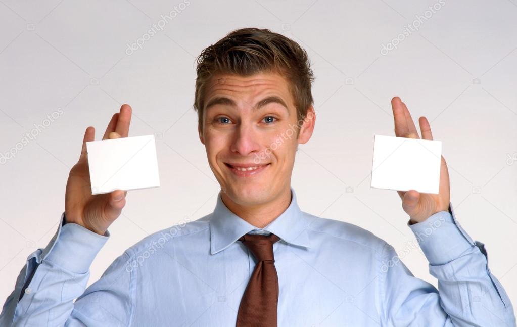 Young businessman holding two white cards
