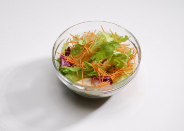 beyaz zemin üzerinde bir sebze salata kasesi.