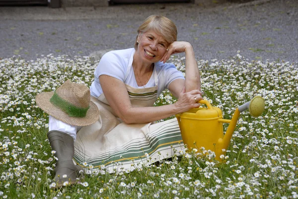 Średni dorosły kobieta gardening.watering roślin. — Zdjęcie stockowe