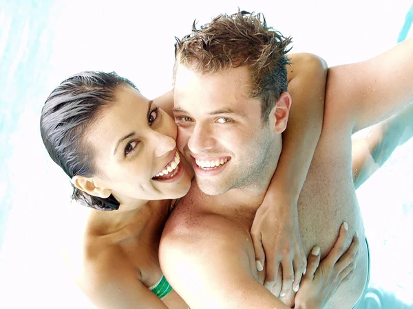 Casal jovem hispânico desfrutando em uma piscina . — Fotografia de Stock