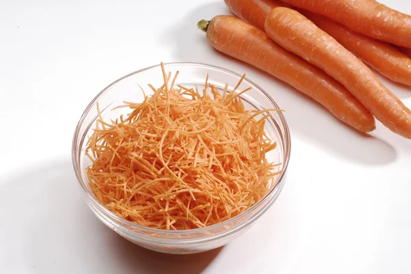Zanahoria fresca en tazón de cristal y zanahorias. Zanahoria fresca en tazón de vidrio y cohete . — Foto de Stock