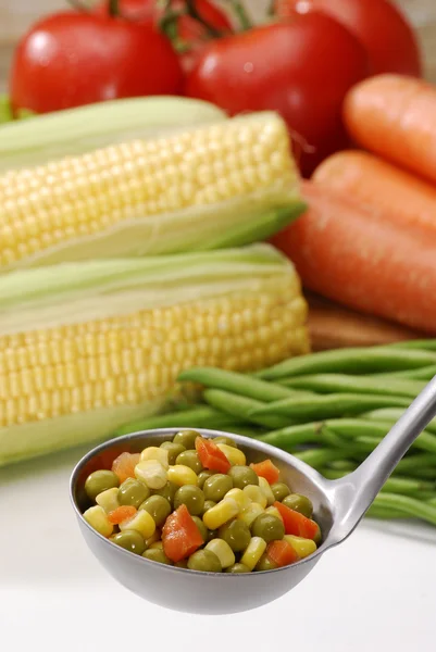 Metallic spoon with boiled fresh mixed vegetables on it. — Stock Photo, Image