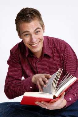 mutlu genç adam tutarak ve kitap okuma.
