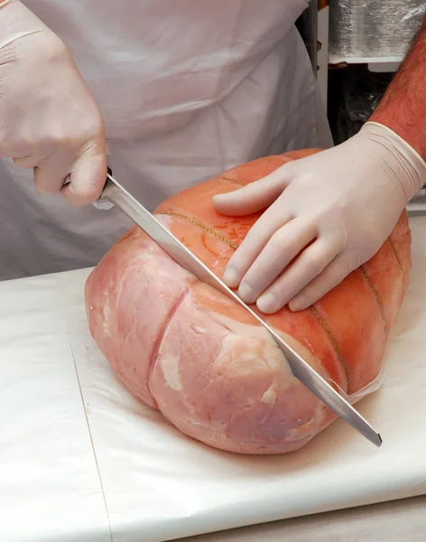 Butcher meat working on a prosciutto ham portion. — Stock Photo, Image