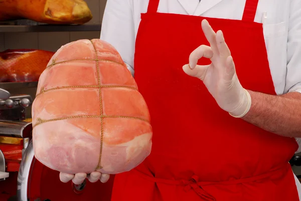 Açougueiro segurando presunto tradicional prosciutto — Fotografia de Stock