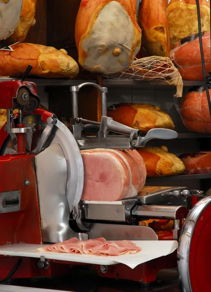 Cortadora de jamón y jamón prosciutto en un almacén . — Foto de Stock