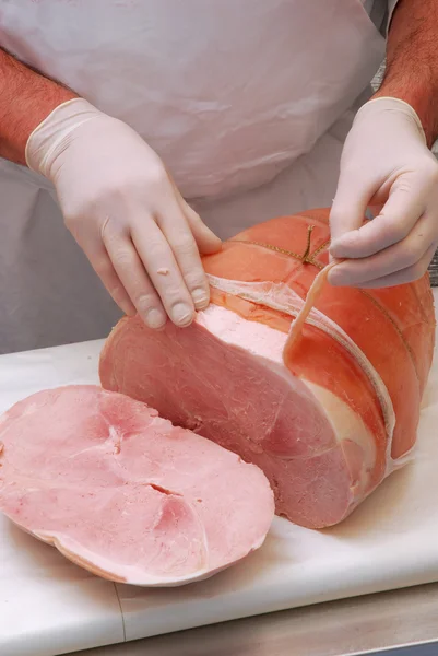 Carnicero trabajando en una porción de jamón prosciutto . —  Fotos de Stock