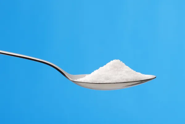 Sugar teaspoon on blue background. — Stock Photo, Image