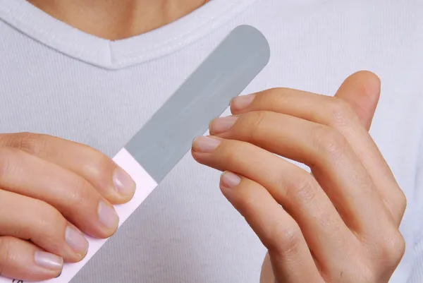 Cuidado corporal de las manos. Mujer puliendo uñas con la lima de uñas . — Foto de Stock