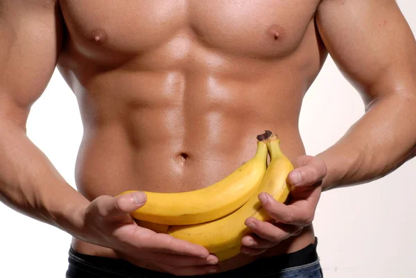 Shaped and healthy body man holding a fresh bananas — Stock Photo, Image