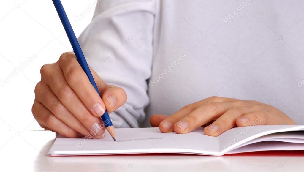 Female writing on a notebook.Holding a blue pencil.
