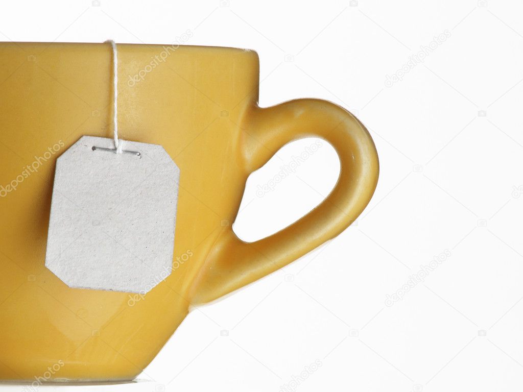 Hot tea bag on yellow cup.