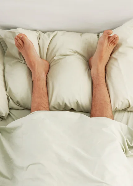 Pieds d'homme sous une couverture blanche — Photo