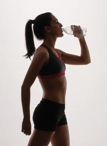 Porträt einer jungen Frau in Sportkleidung und Trinkwasser — Stockfoto