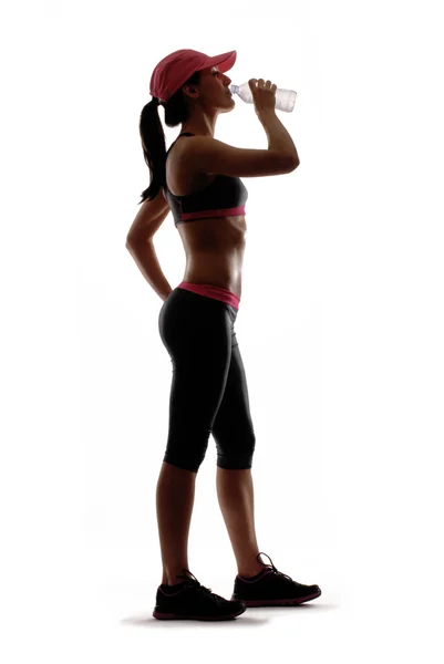 Portrait of young woman wearing sport clothes and drinking water — Stock Photo, Image