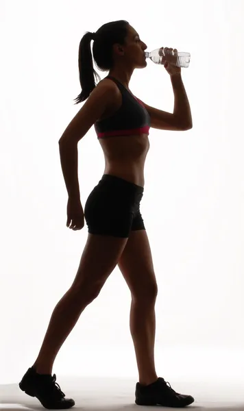 Retrato de mulher jovem vestindo roupas esportivas e água potável — Fotografia de Stock