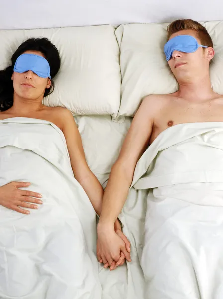 Sleeping couple in sleep eye mask on bed. — Stock Photo, Image