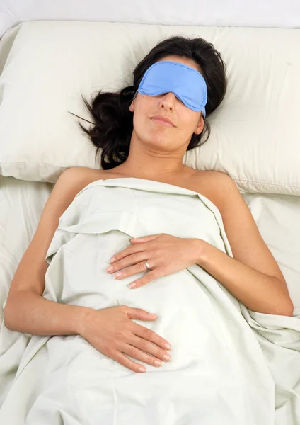 Durmiendo joven mujer en sueño ojo máscara en la cama . — Foto de Stock