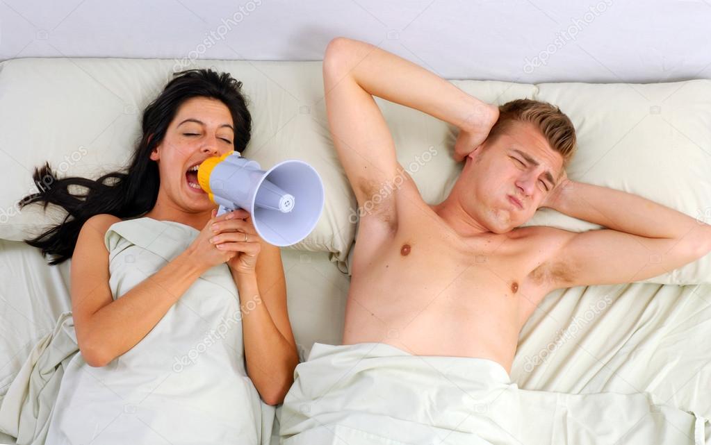 Funny couple in bed waking up in the morning.Using megaphone