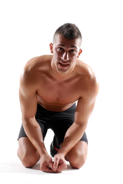 Junger muskulöser Mann sitzt auf dem Boden — Stockfoto