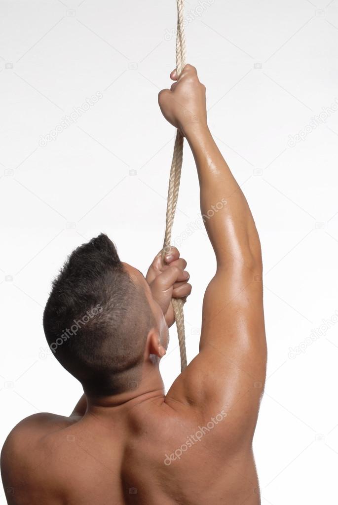 Young man trying to climbing rope