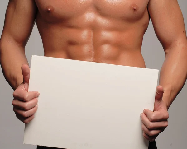 Hombre de cuerpo en forma y saludable sosteniendo un panel blanco, en forma abdominal —  Fotos de Stock