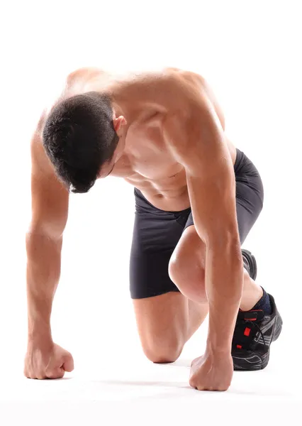 Homem saudável e fitness na posição de início de corrida no fundo branco . — Fotografia de Stock