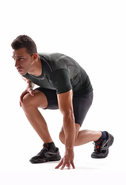 Gesunder und fitter Mann auf Laufstartposition auf weißem Hintergrund. — Stockfoto