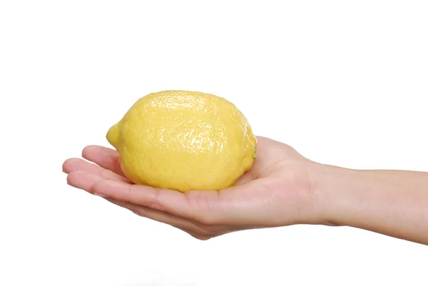 En ung kvinnlig hand håller en gul citron. — Stockfoto