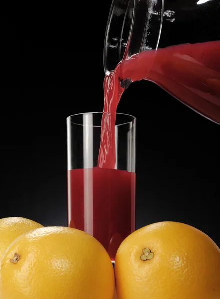 Despejando suco de laranja vermelho fresco — Fotografia de Stock