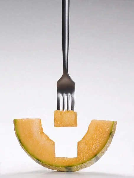 Äta melon. gaffel punktera melon bit. — Stockfoto