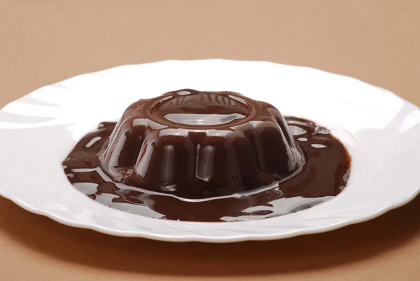 One chocolate pudding on a plate. One chocolate flan in a plate. — Stock Photo, Image