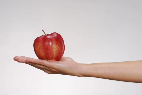 Mão feminina segurando uma maçã fresca . — Fotografia de Stock