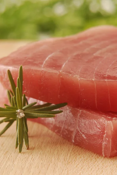 Two tuna steaks and rosemary. — Stock Photo, Image