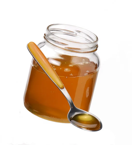 Honey in the pot and a spoon — Stock Photo, Image