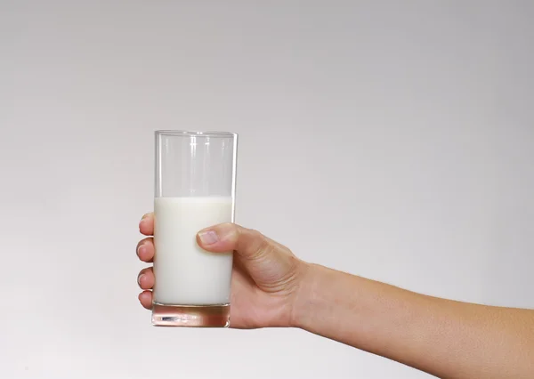 Één volgens vrouwelijke hand met een glas melk. — Stockfoto