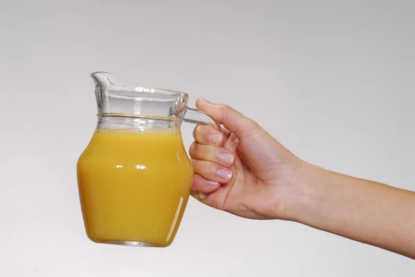 Женщина держит в руке апельсиновый сок — стоковое фото